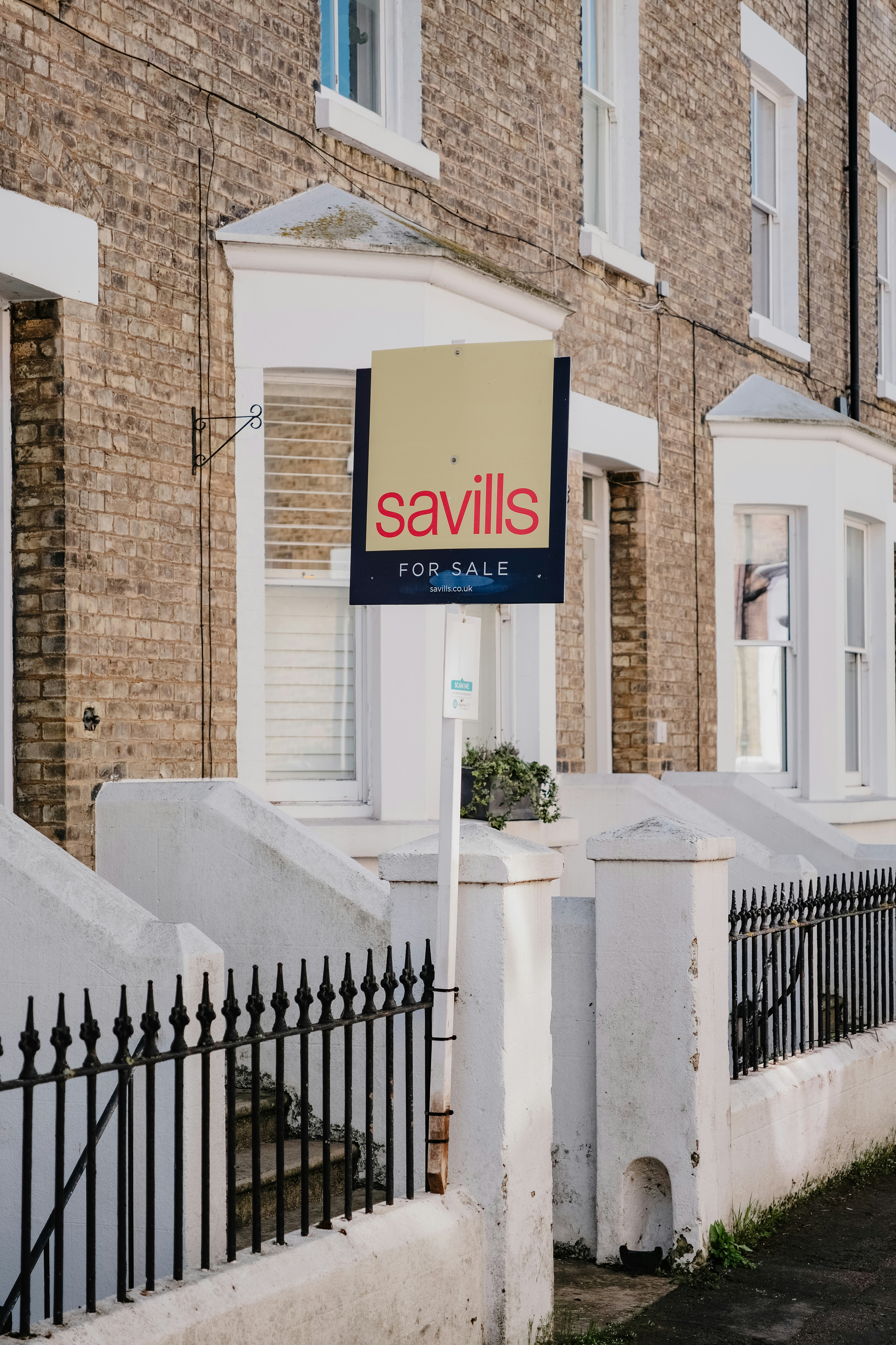 Savills for sale sign outside brick townhouses
