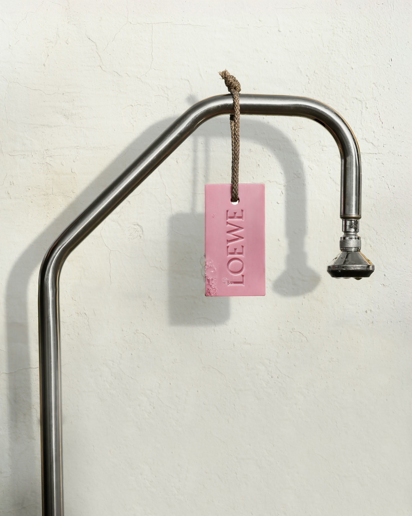 Ivy LOEWE soap bar suspended from a traditional outdoor shower.