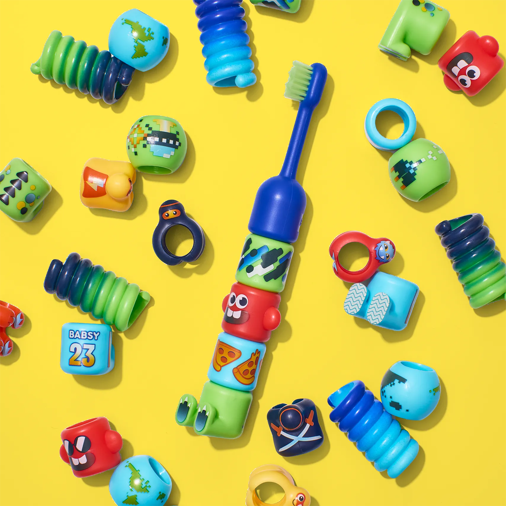 BABSY toothbrush components arranged for production on a yellow background