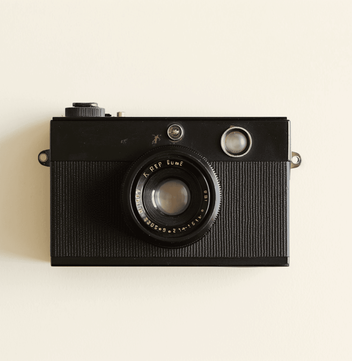 A vintage black camera with a manual lens, textured grip, and classic design.