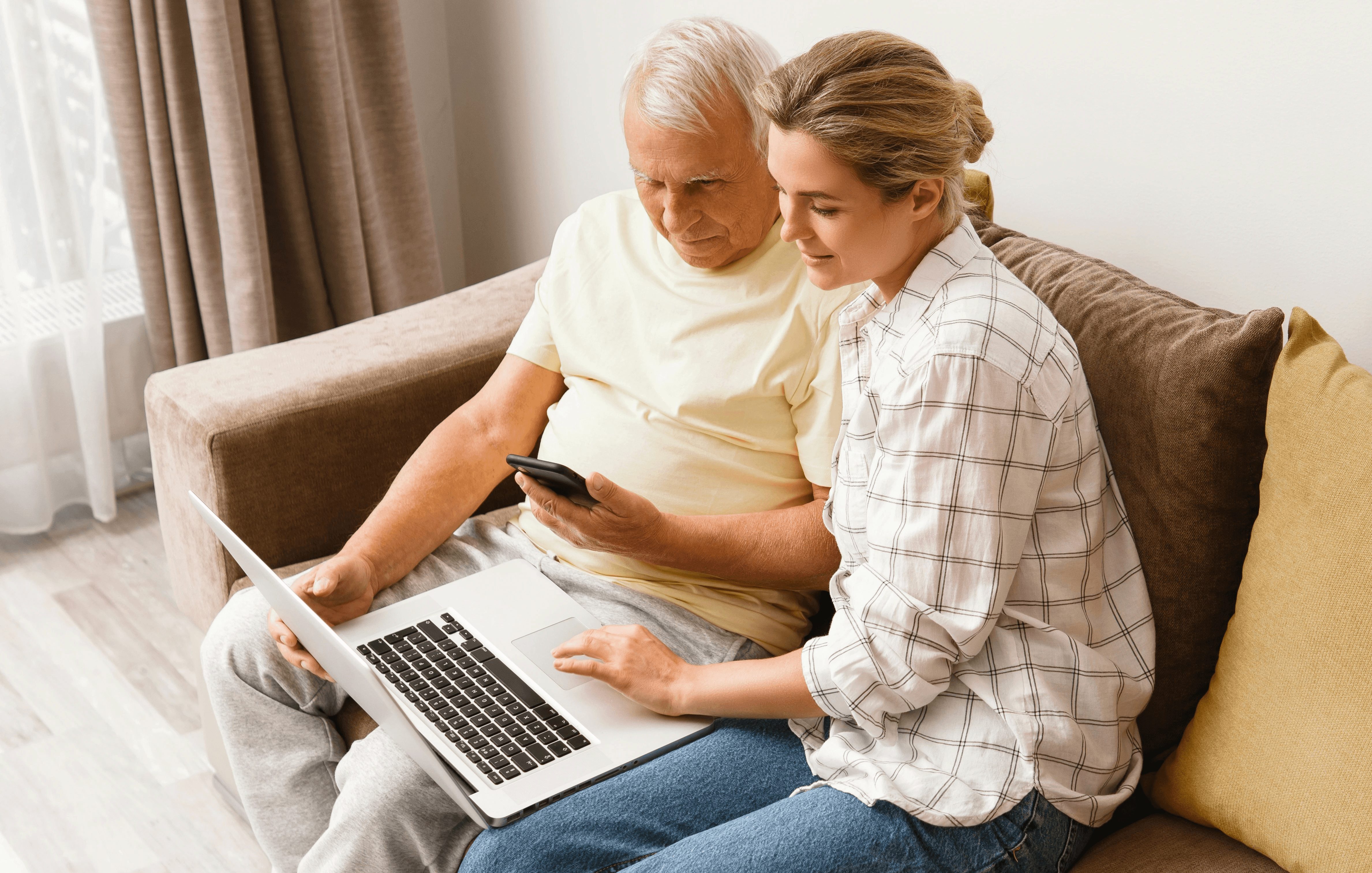 elderly man looking at computer with middle-aged woman