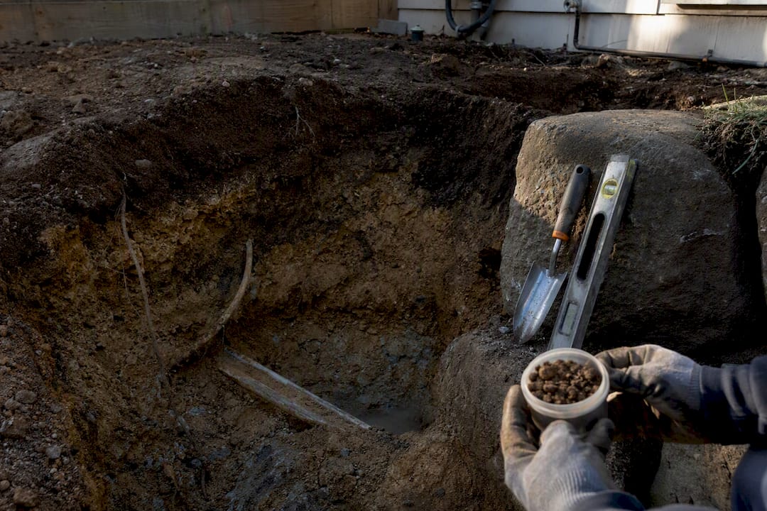 Excavated deck foundation showing unexpected soil and utilities
