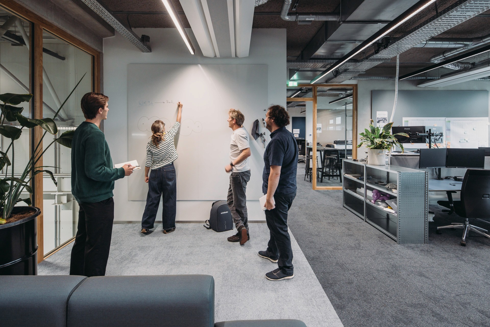 Interior photo of the office floor with open and semi open meeting rooms and workspaces