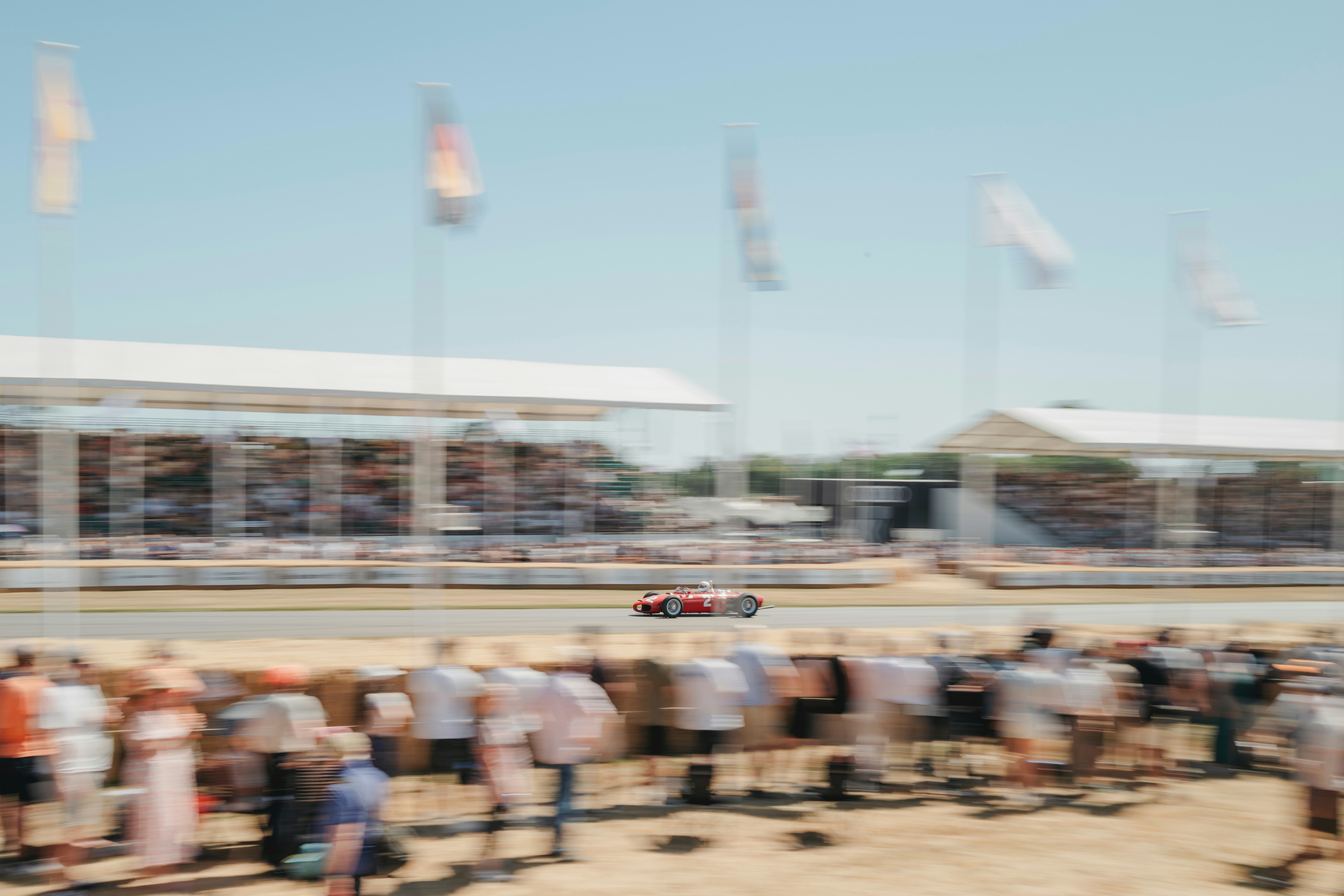 A race car speeds along the track surrounded by crowds.