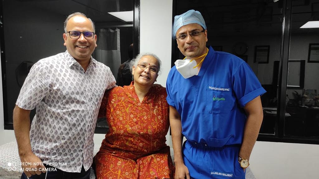 Elderly patient expressing gratitude for pain-free life after robotic joint replacement surgery.