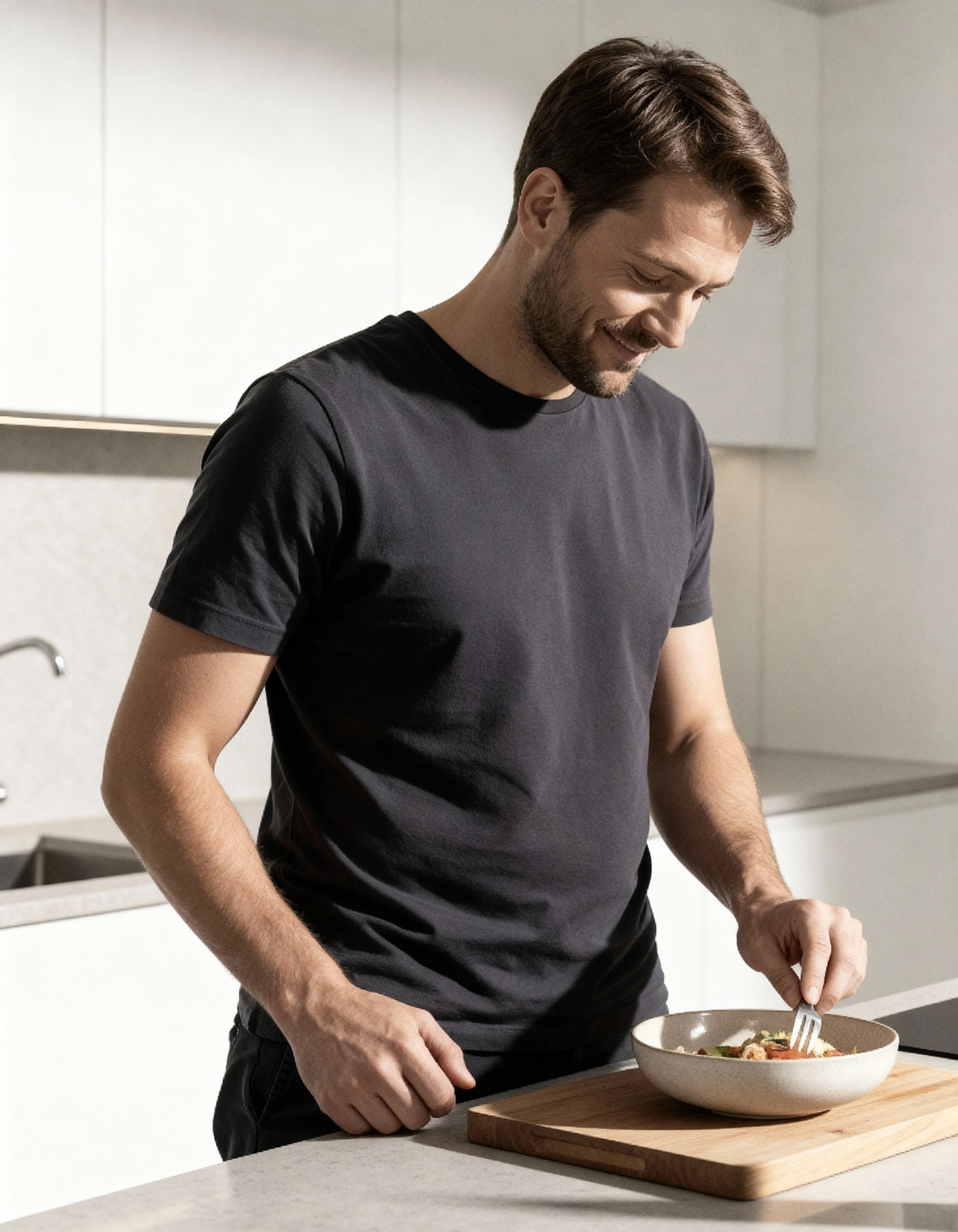 Normaler Mann steht in moderner Küche und bereitet ein gesundes Gericht zu – Darstellung eines bewussten, gesundheitsorientierten Lebensstils