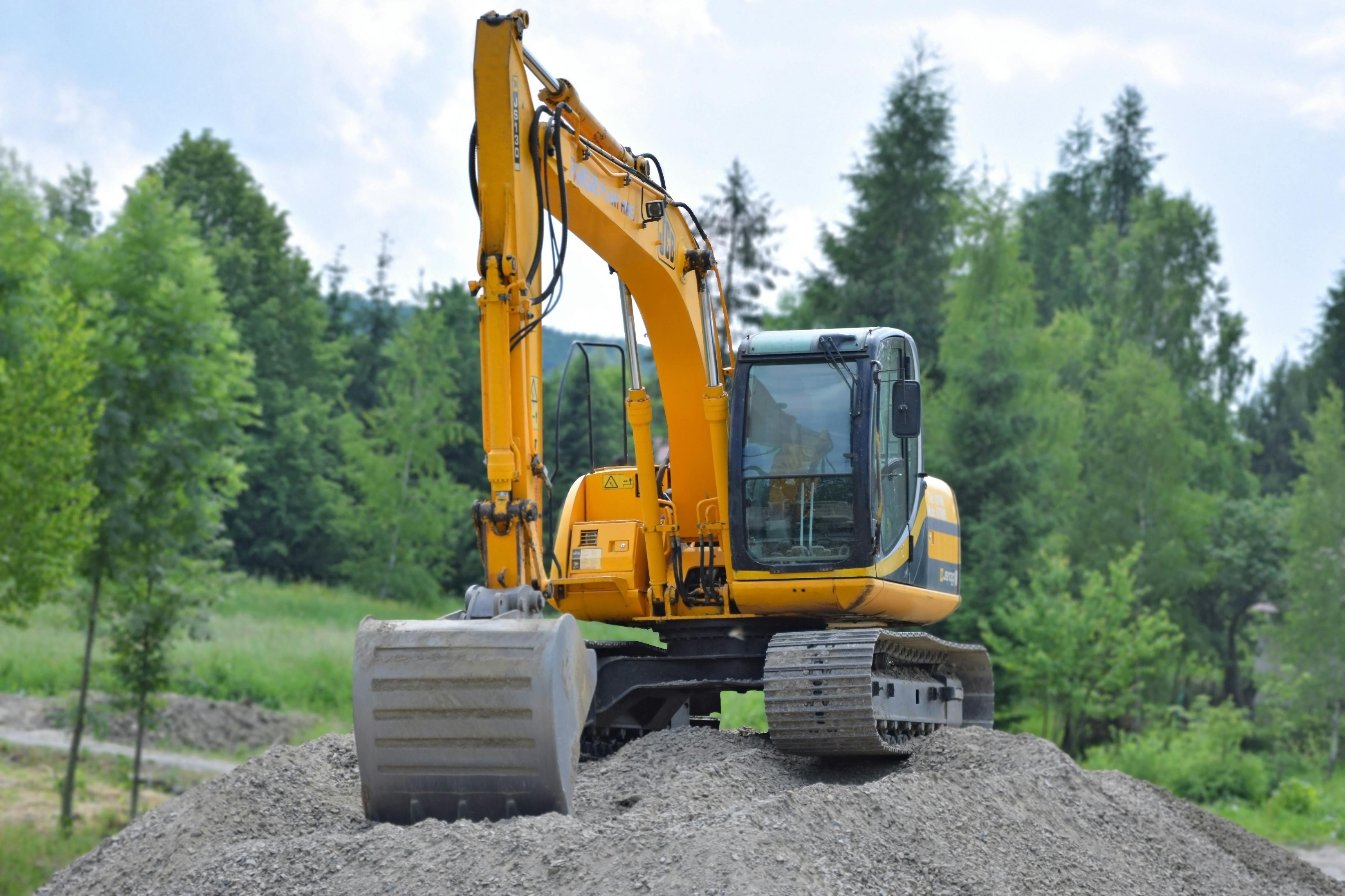 yellow and black excavator on brown soil
