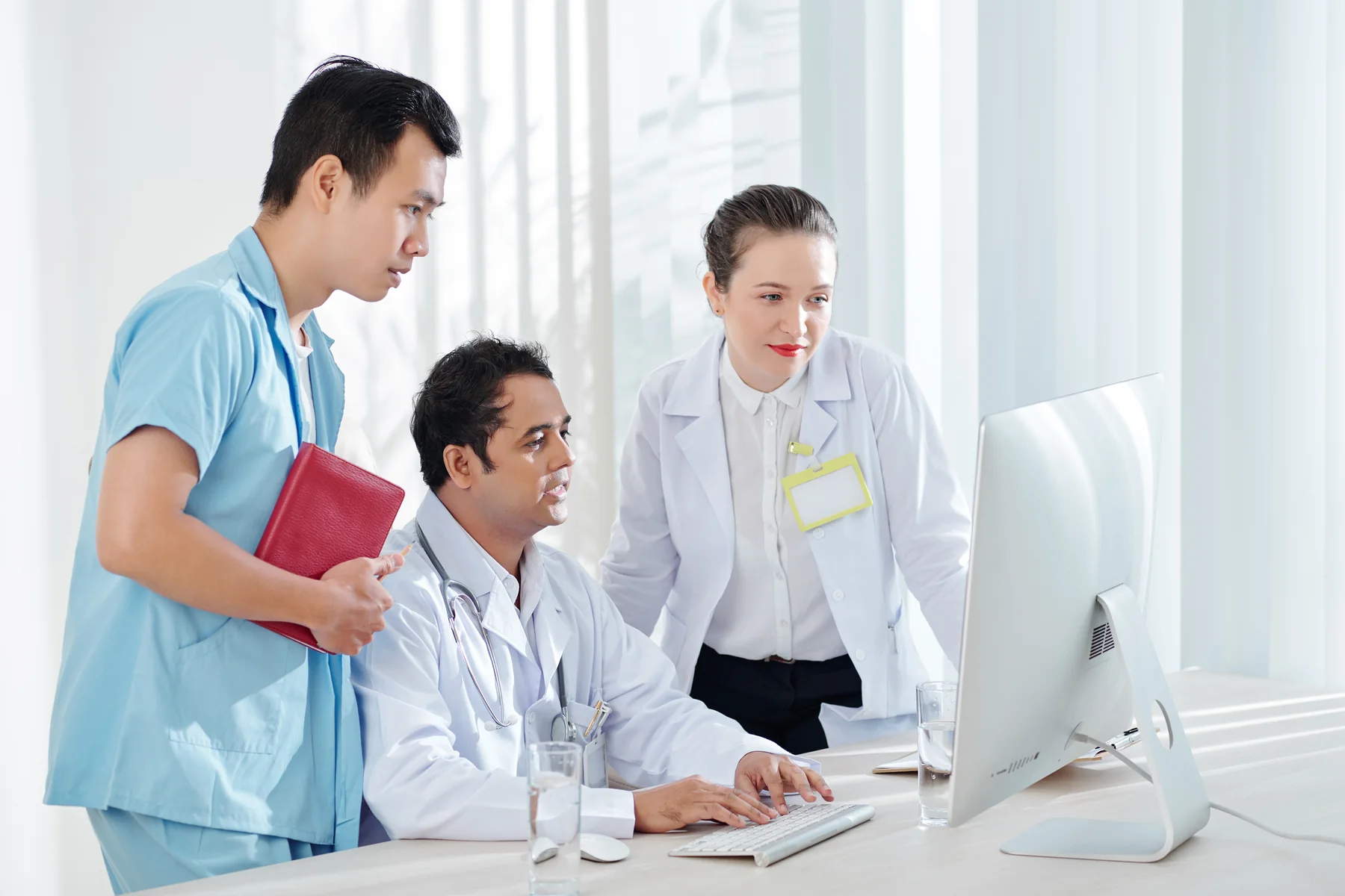 Doctors Analyzing Computer in Modern Bright Office