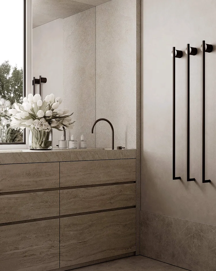 Modern minimalist bathroom with stone vanity, elegant faucet, and fresh tulips.