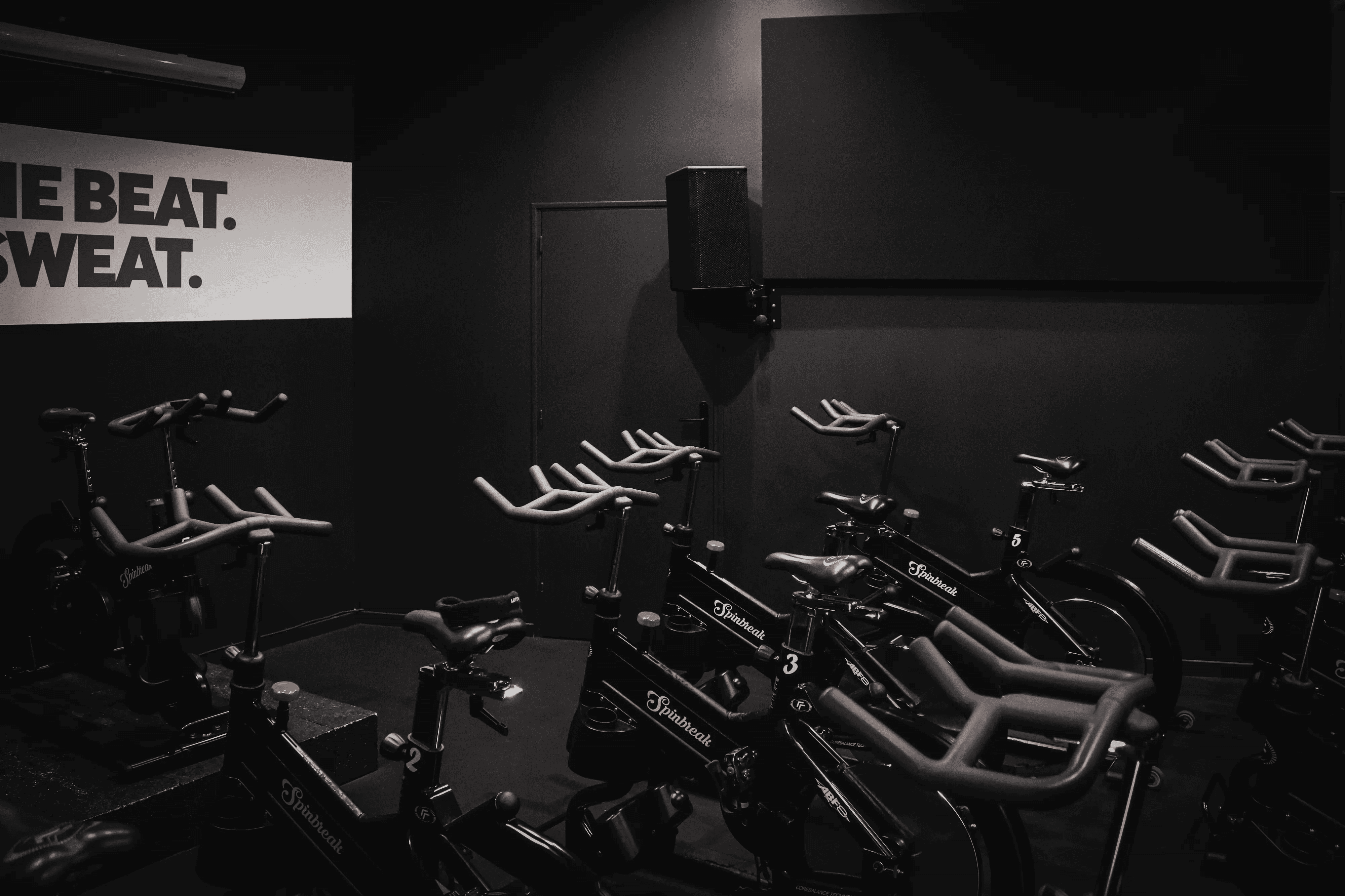 Salle de cycling sombre avec vélos alignés dans la Spin Room