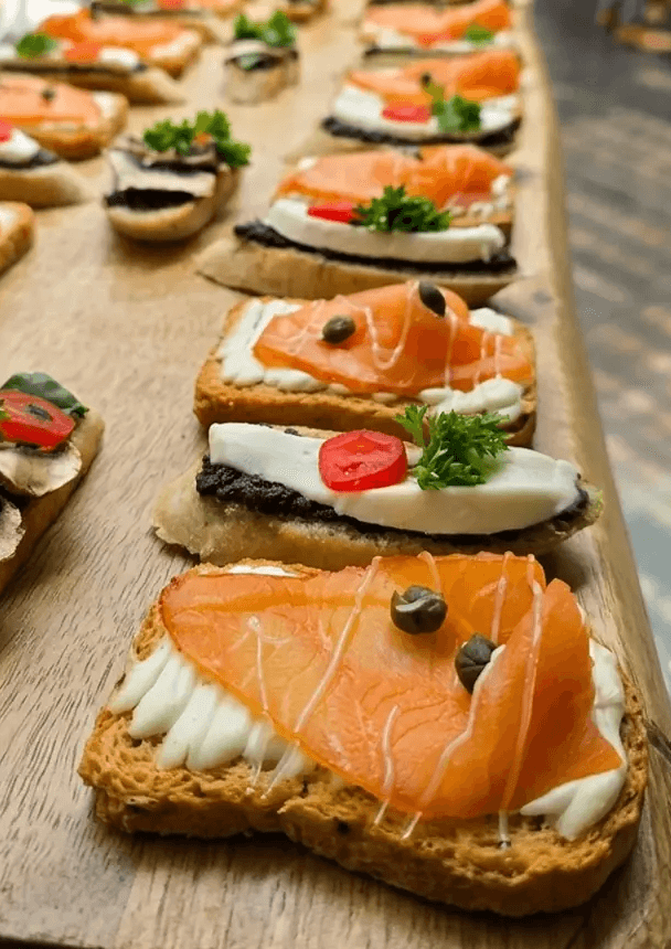 Bruschettas de carpaccio de salmón ahumado para banquetería fina y eventos corporativos en Las Condes.