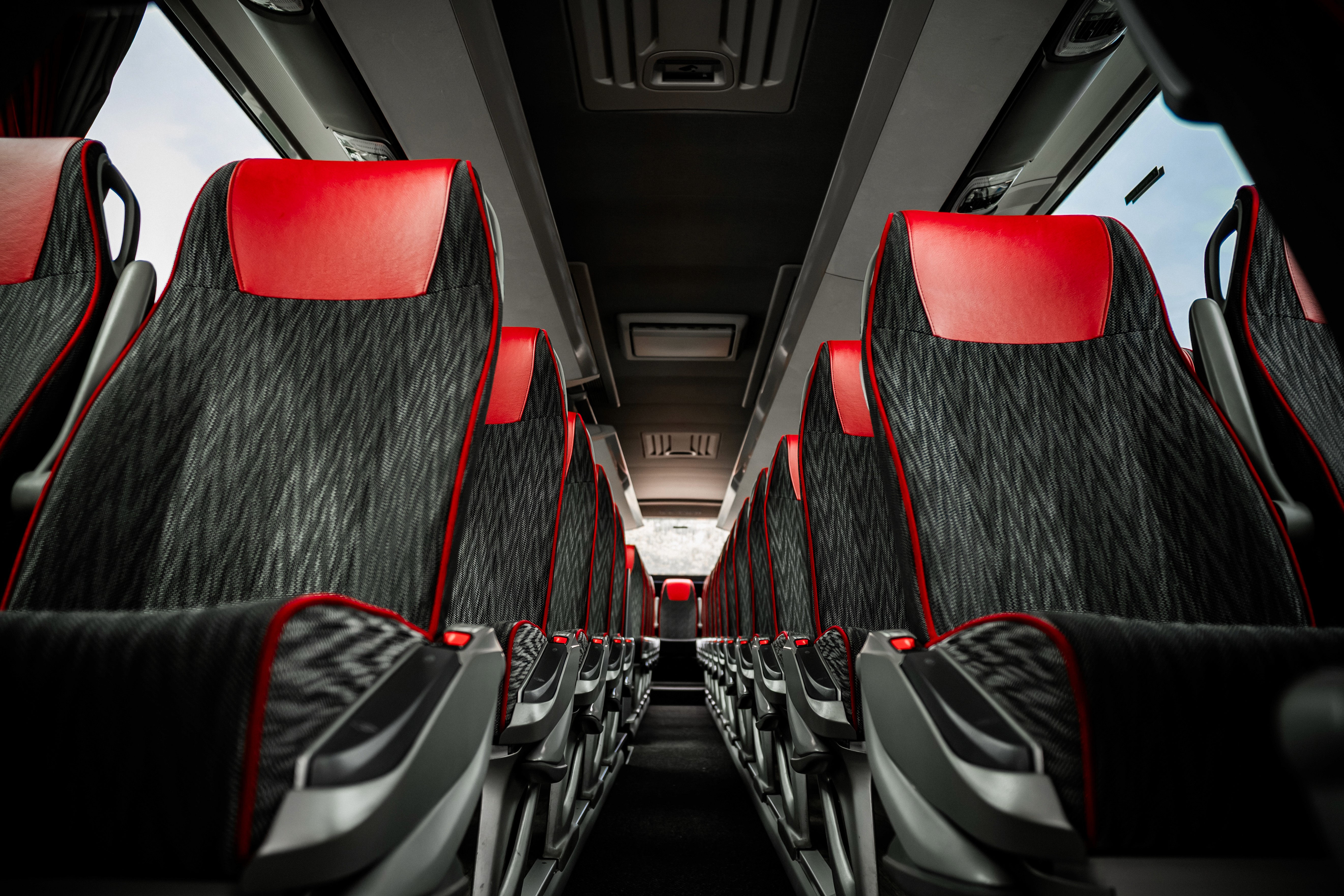person in orange jacket standing on brown rock near snow covered mountain during daytime