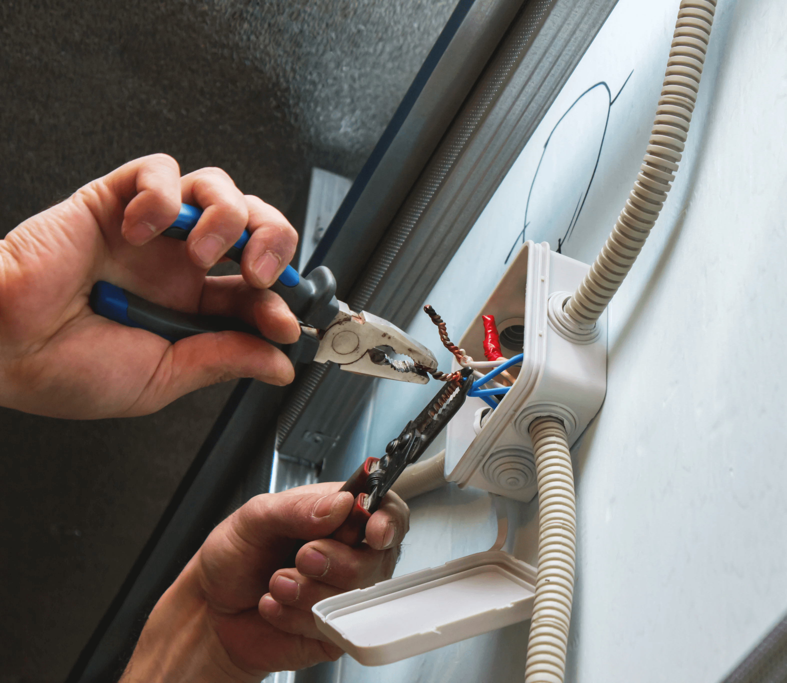 Eletricista da equipe TCC Especialização realizando instalação elétrica em uma residência, utilizando ferramentas para conectar fios em uma caixa de distribuição.