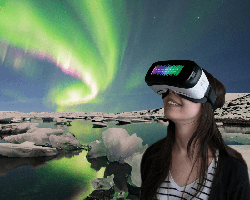 Visitor using VR headset at Aurora Reykjavik Northern Lights Center with aurora borealis over glacier lagoon—interactive exhibit and popular thing to do in Reykjavik.