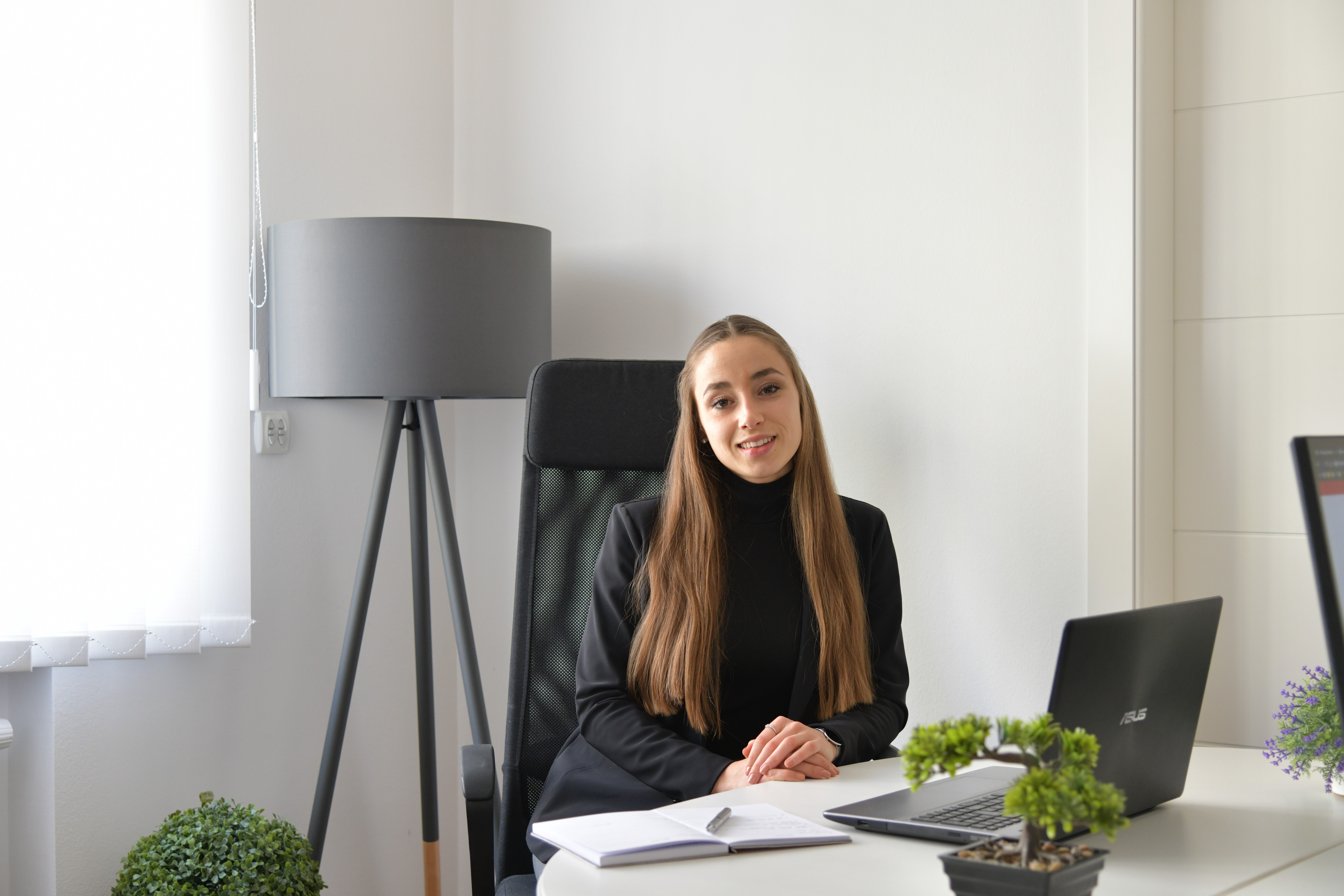 woman in blue tank top standing beside white wall