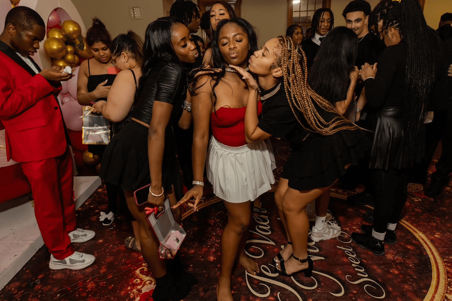 A group of friends enjoy a lively party, posing together in stylish outfits and vibrant surroundings.