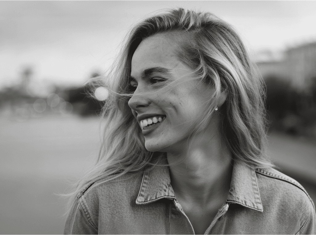 Smiling woman looking sideways in a black and white portrait