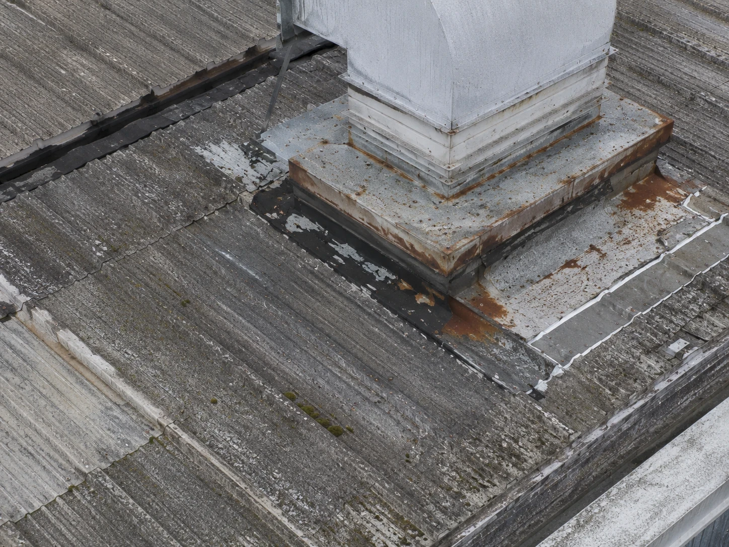 Close aerial inspection of roof flashing and gutter detail showing a visible defect