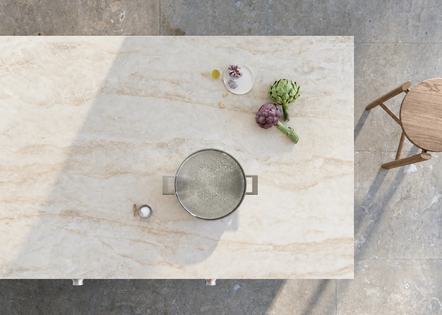 Vue de dessus d’un plan de travail Dekton clair avec des artichauts et un récipient de cuisson