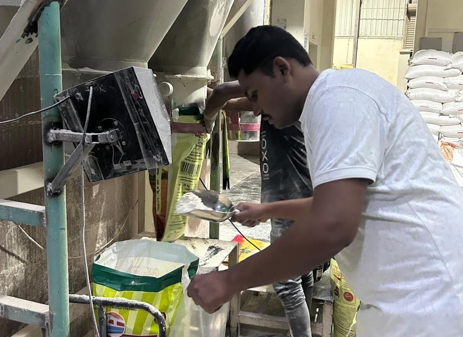 Flour mill worker fortifying wheat flour