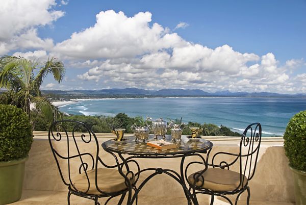 Table and chairs with tea set facing ocean view