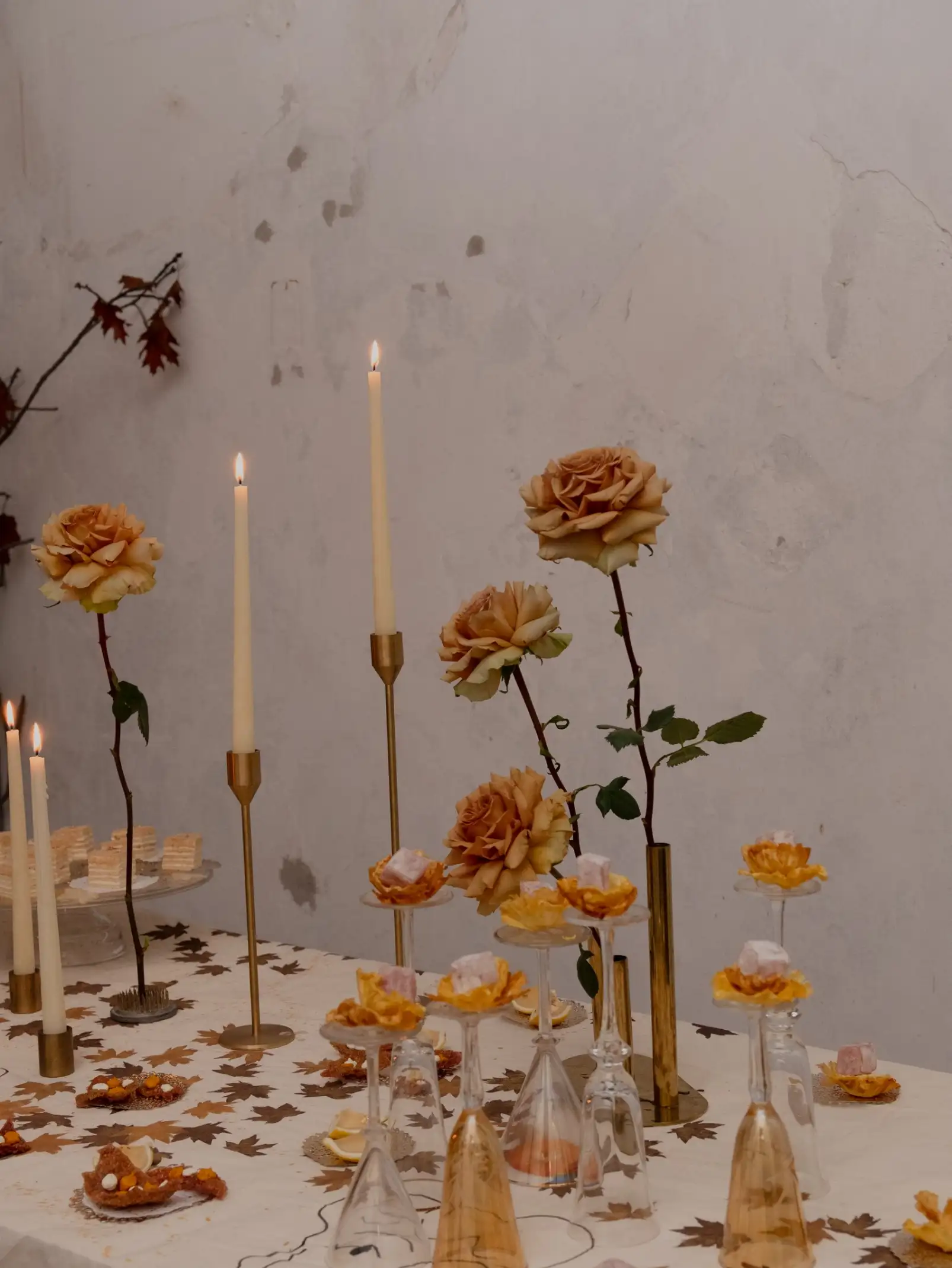 Centro de mesa con flores y dulces en copas de cristal para evento estacional, evocando calidez y detalle artesanal.