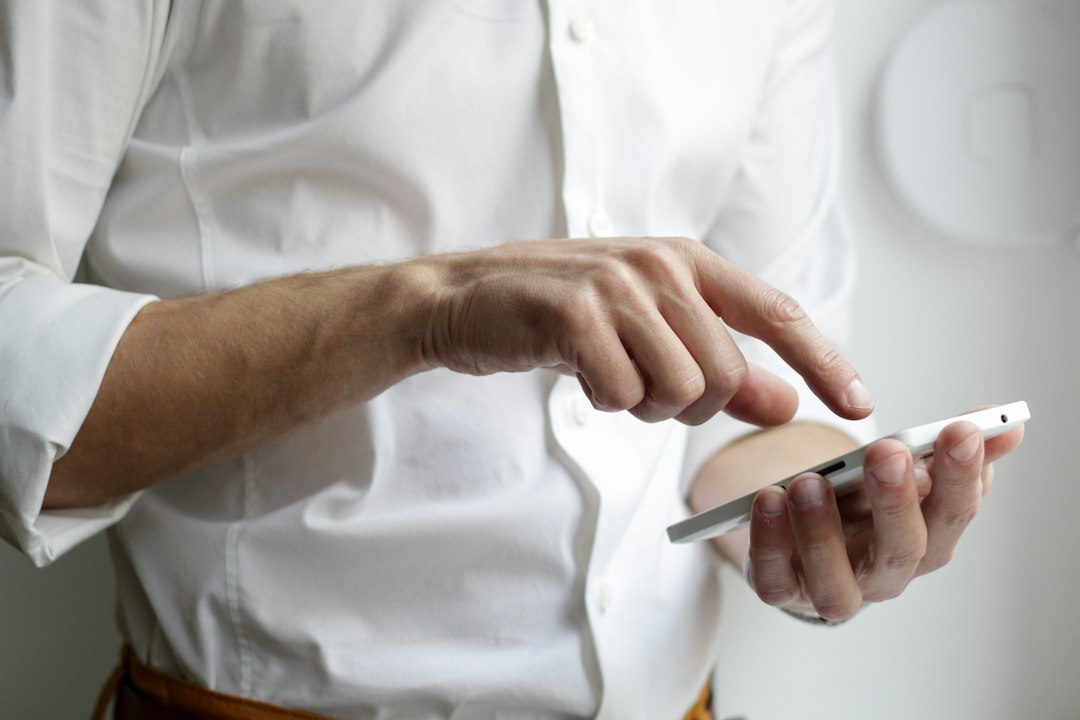 close-up of a smartphone hand-held by a server in a cafe, showing a notification for an available shift, espresso machine in the background