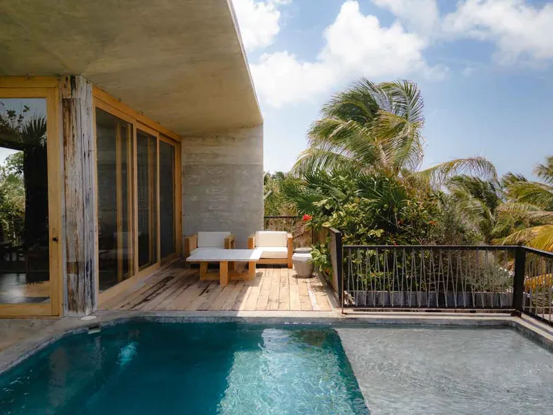 Pool area surrounded by jungle ambiance with loungers and tranquility at Be Tulum.