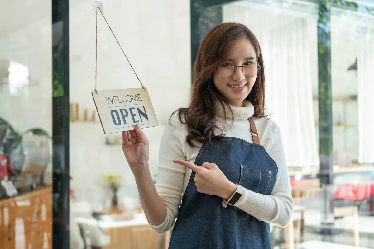 A small business owner displaying an open sign