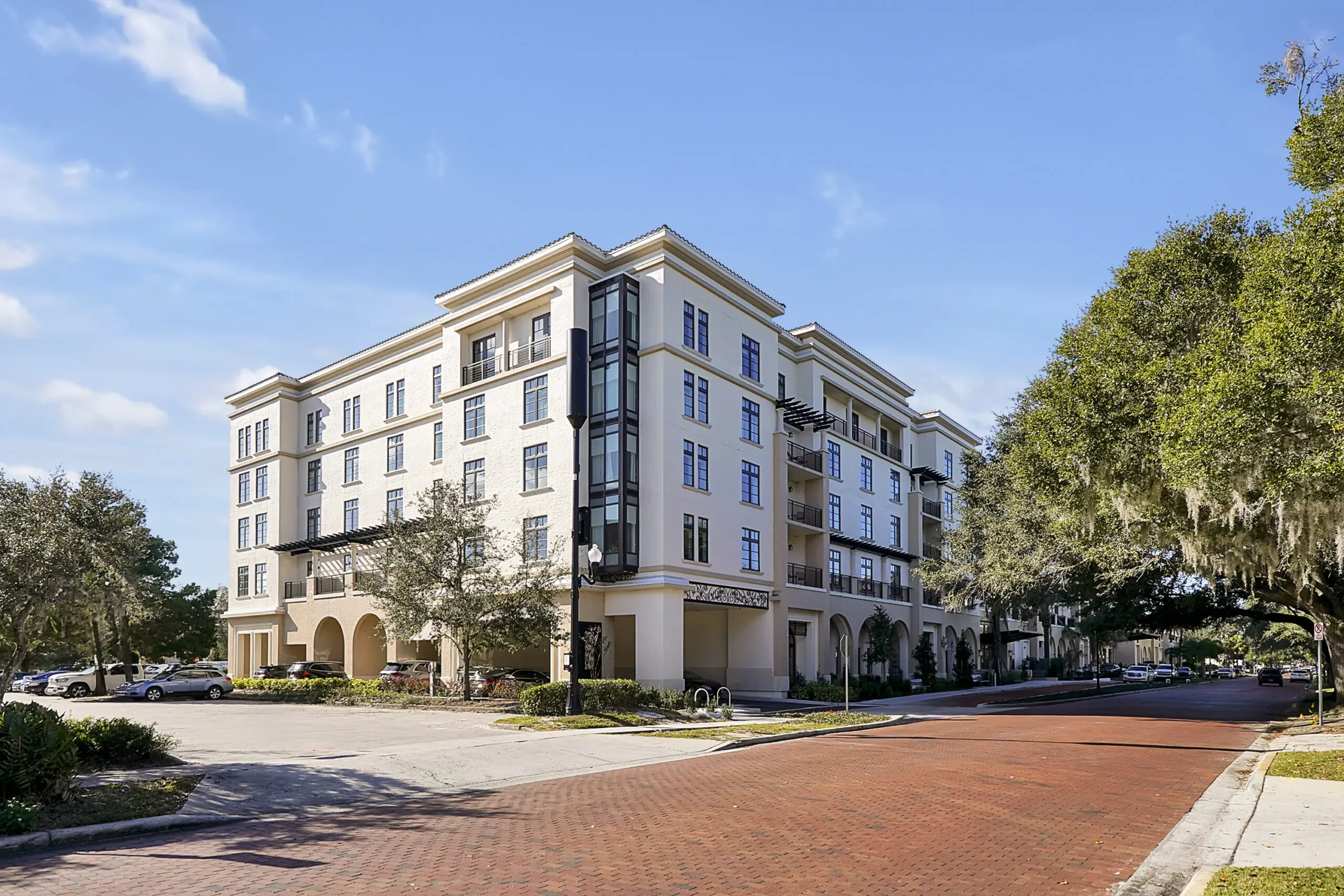 Cream-colored building with balconies and trees