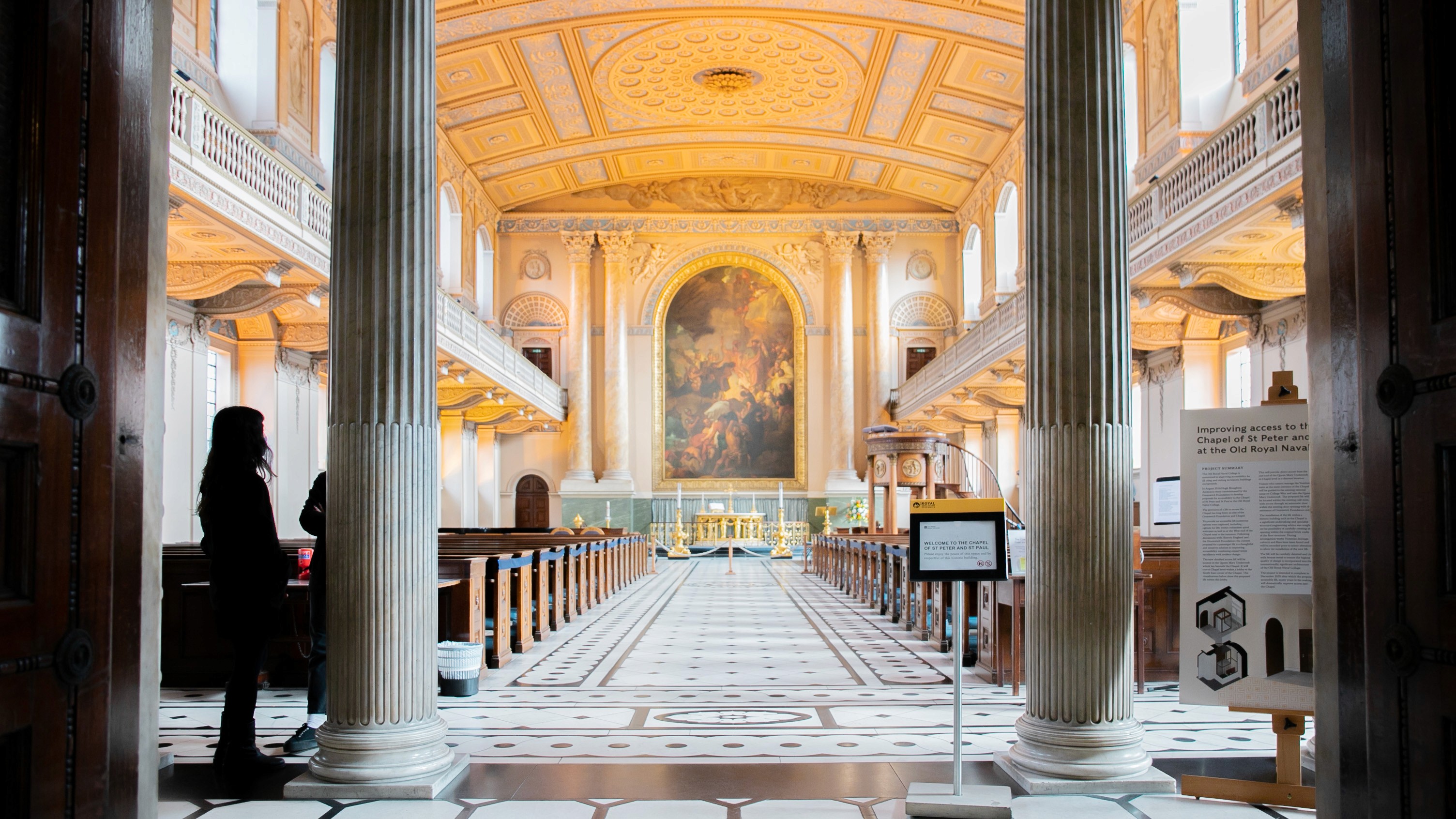 Two classic volkswagen beetles, one green, one cream.
