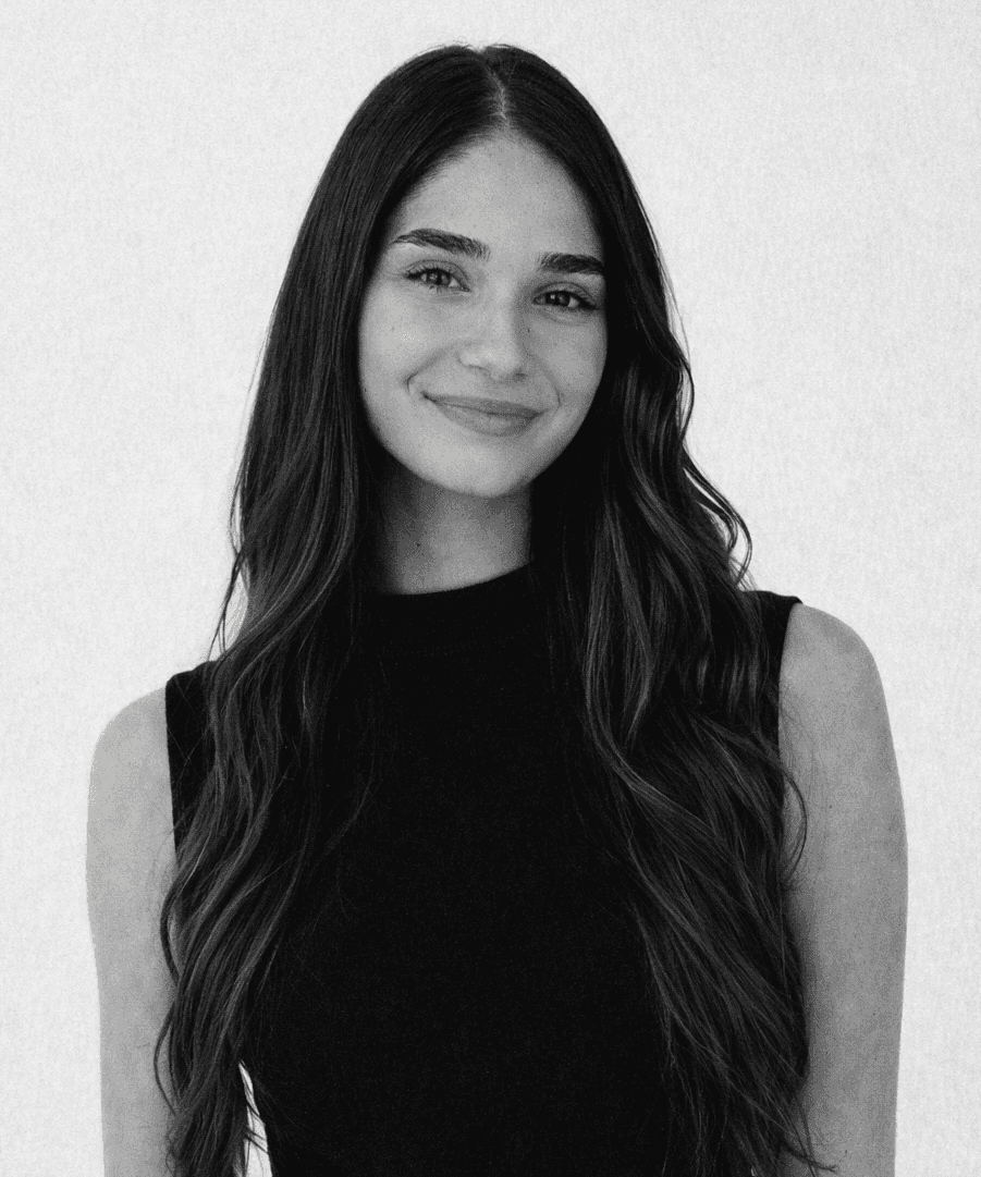 A thoughtful young person with dark hair gazes to the side, captured in soft black and white lighting.