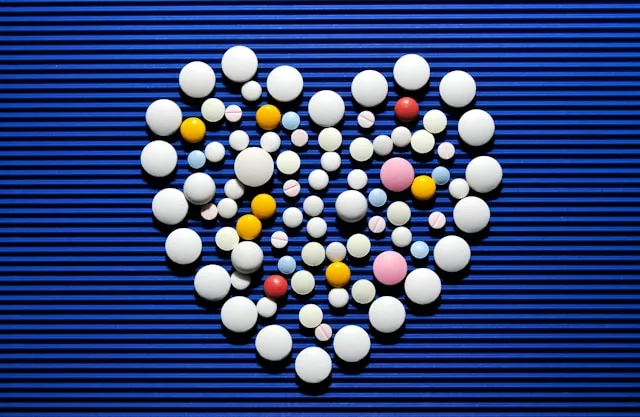 Amber softgel capsules of CoQ10 on a navy background in a heart form, marketed for daily heart support and energy.