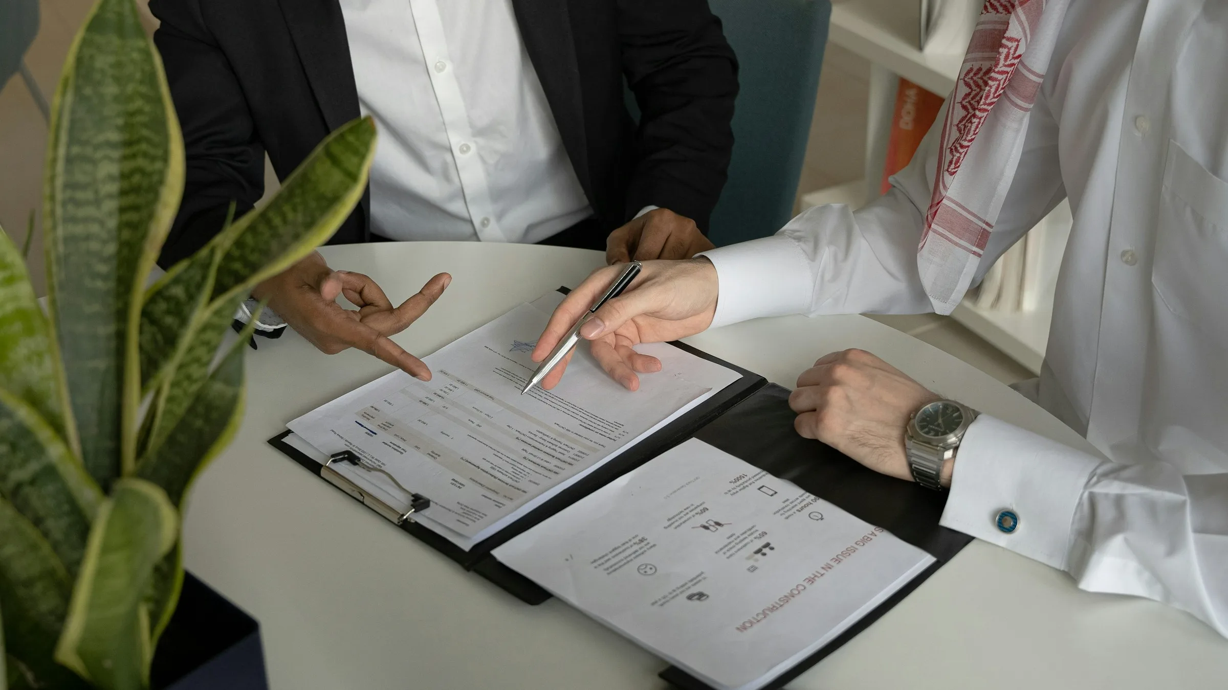 Two business people reviewing and signing a contract at a table
