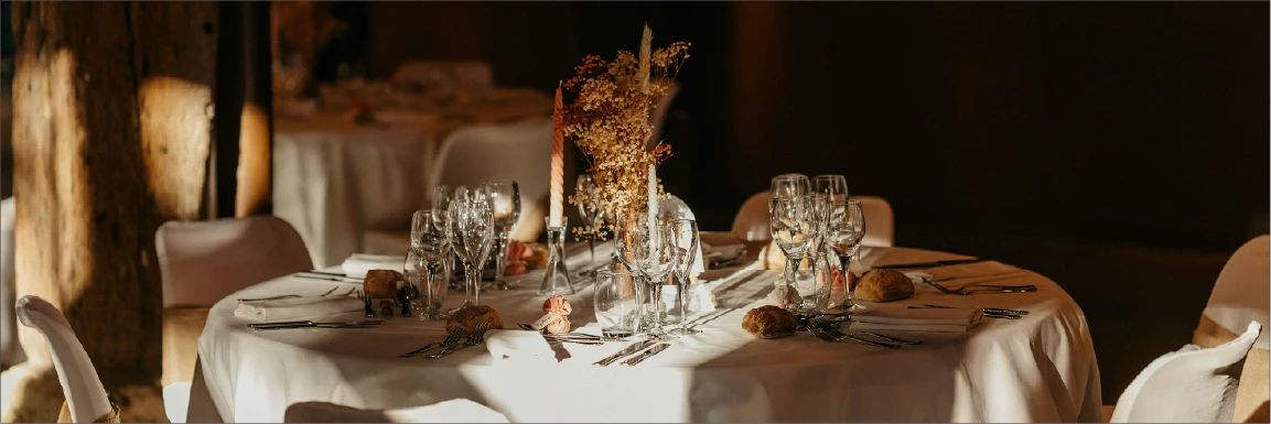 A formal table setting with floral arrangements and candles.