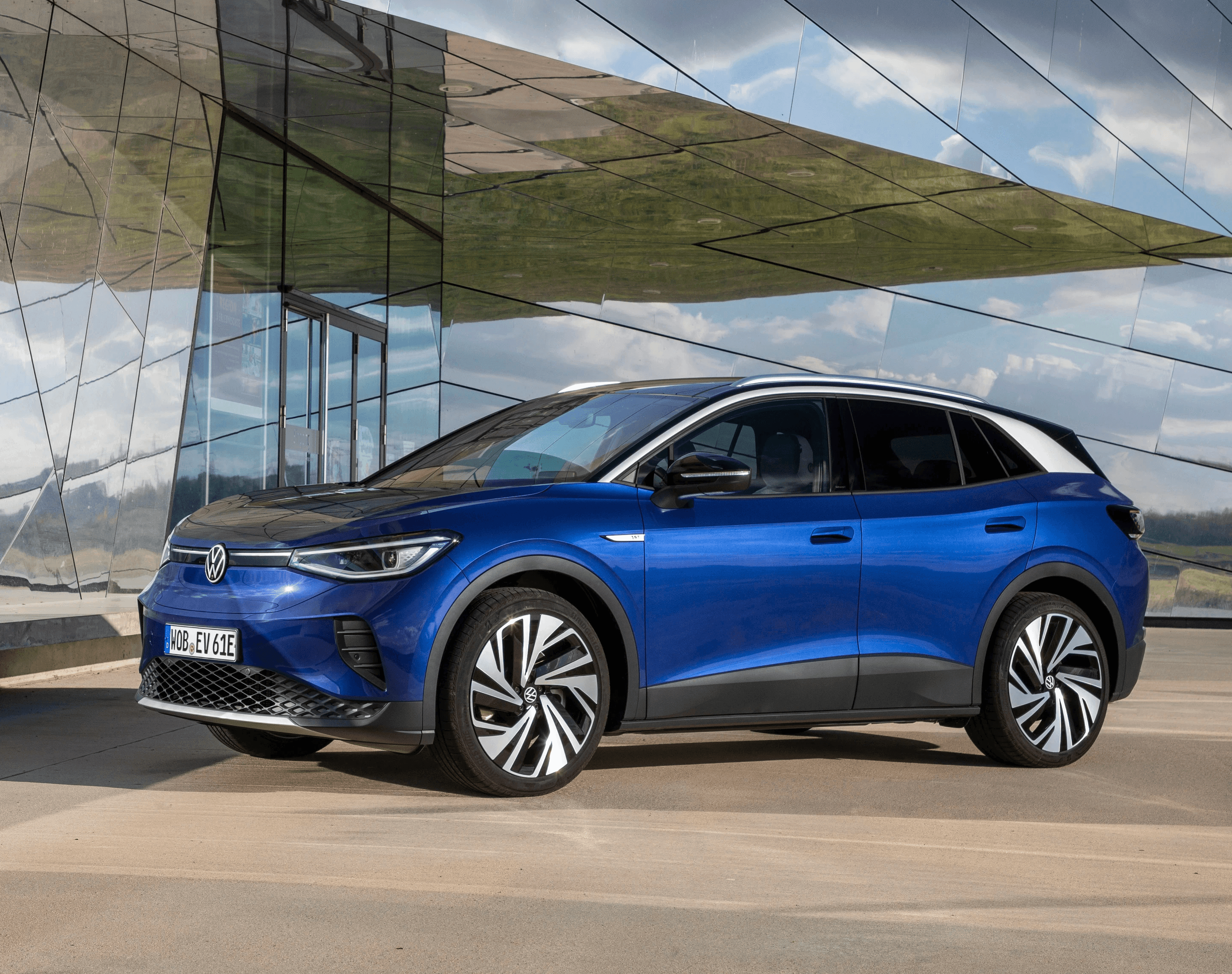 Volkswagen ID.4 bleue en extérieur devant une architecture moderne, SUV électrique vu de face