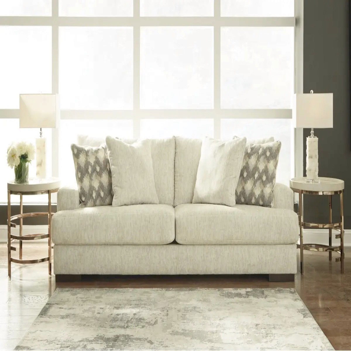 Ashley Caretti sofa in a light beige tone, paired with matching pillows and elegant side tables