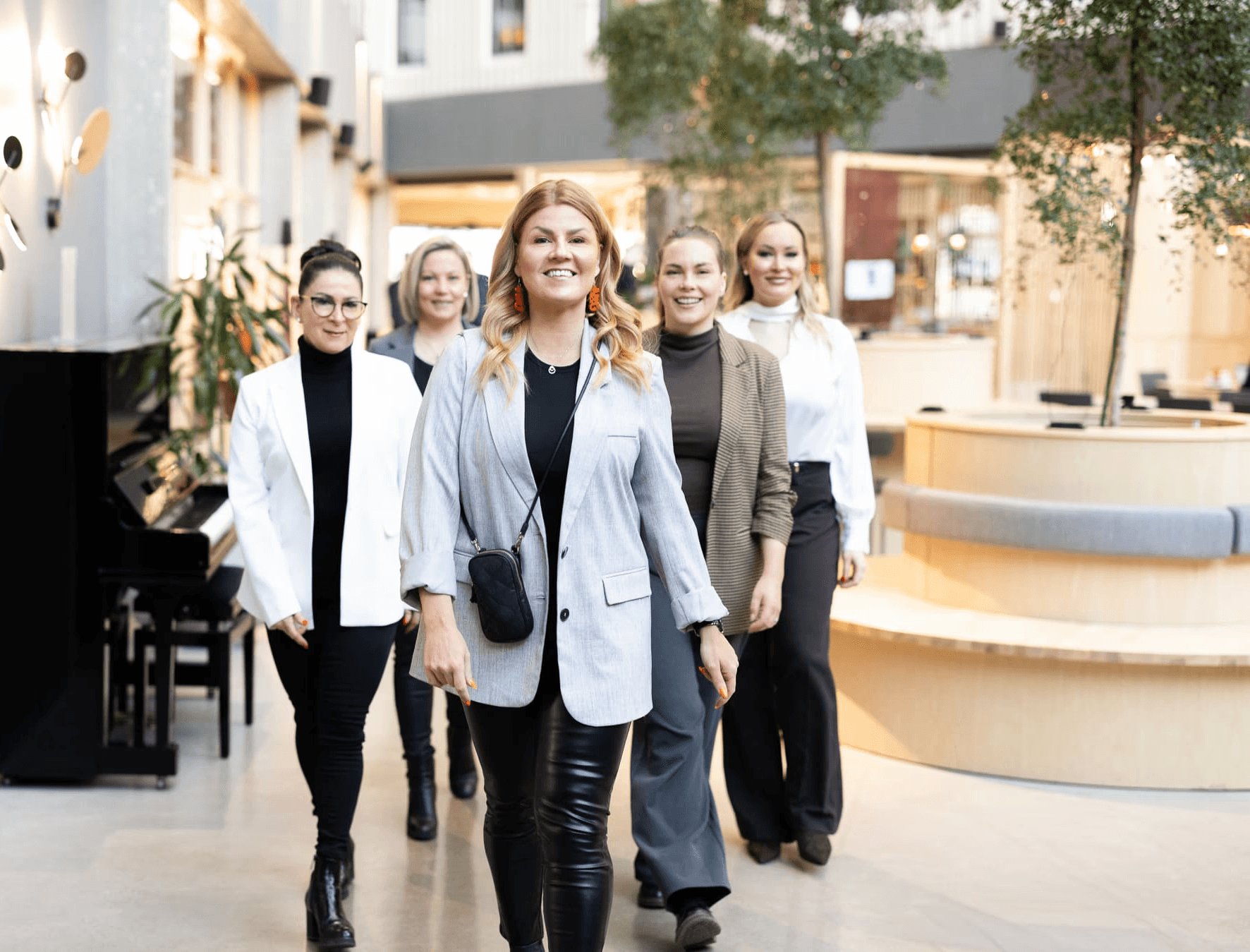 Network & Growthin valmentajatiimi kävelee yhdessä modernissa toimistotilassa.