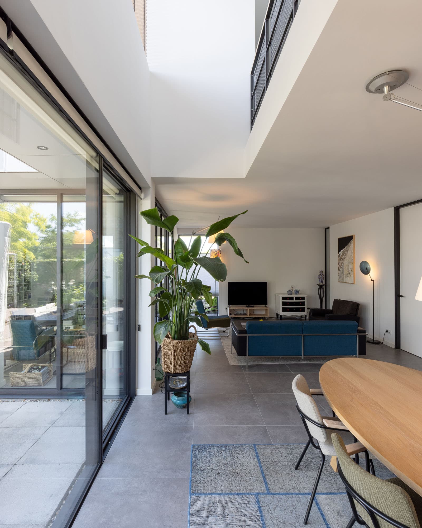 Interieur van Villa Rijswijk met eettafel, grote schuifpui en zicht op de tuin.
