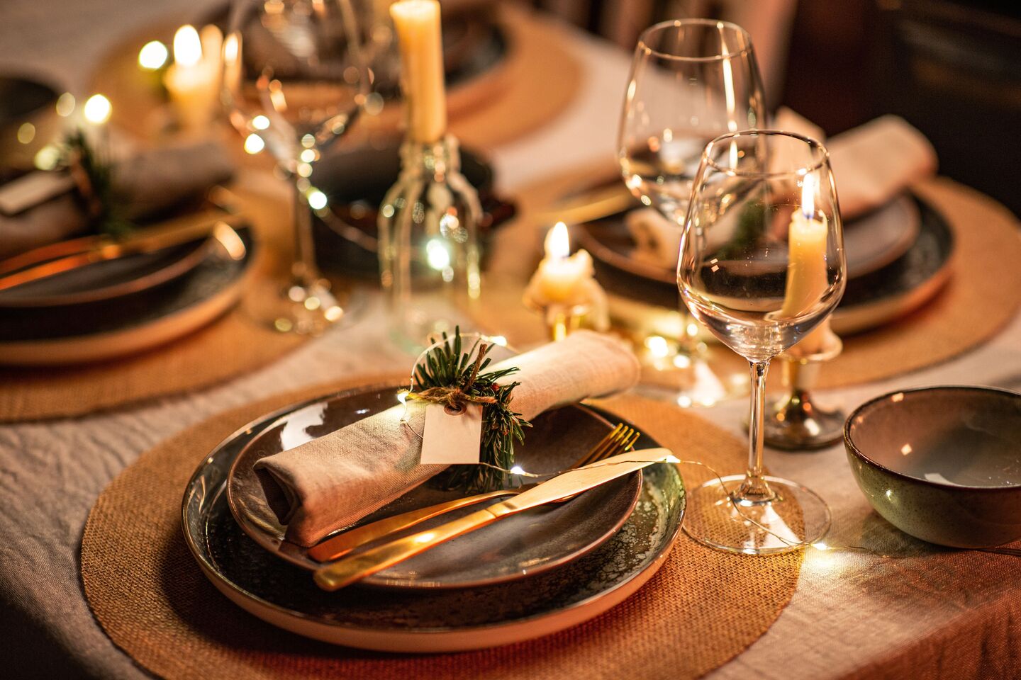 Candlelit dinner table set with plates and wine glasses for a celebration