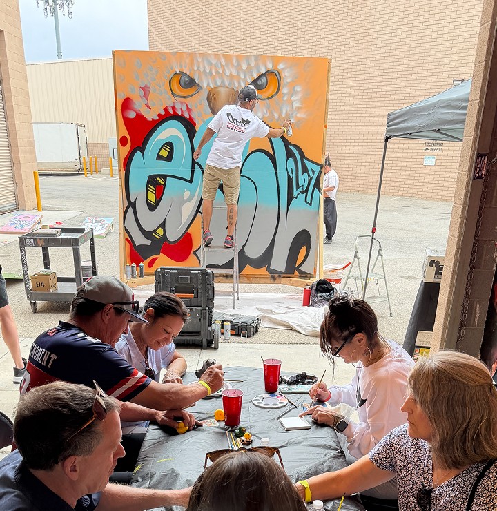 children working on art in front of a live painter