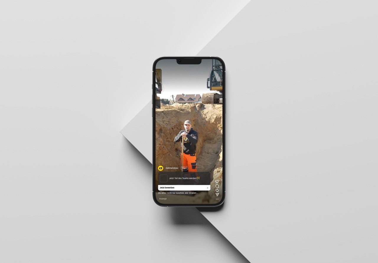 Mobiles Live-Video mit zwei Männern im Freien, angezeigt auf einem modernen Smartphone auf weißem Sockel.