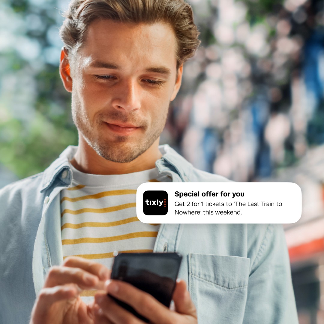 Man on street getting a message with an offer send through Tixly's CRM system