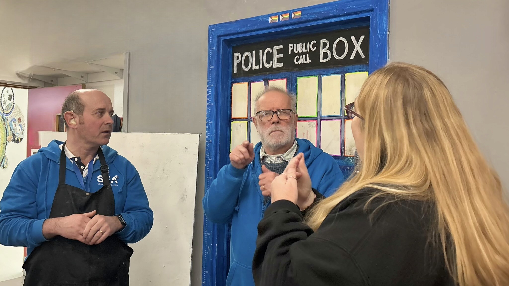 Two support workers signing to interpreter