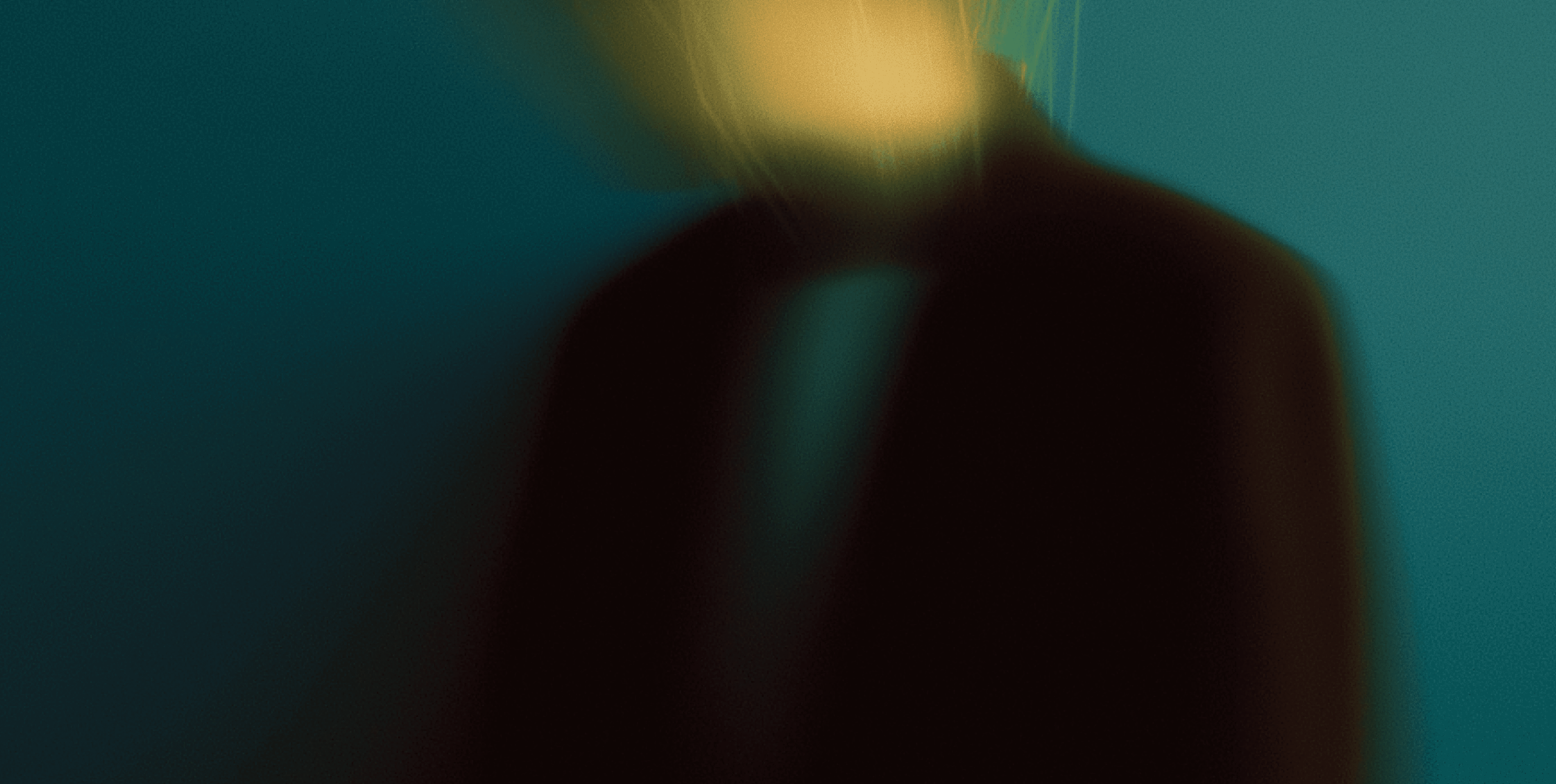 A blurred figure against a dark teal background, creating an abstract effect.