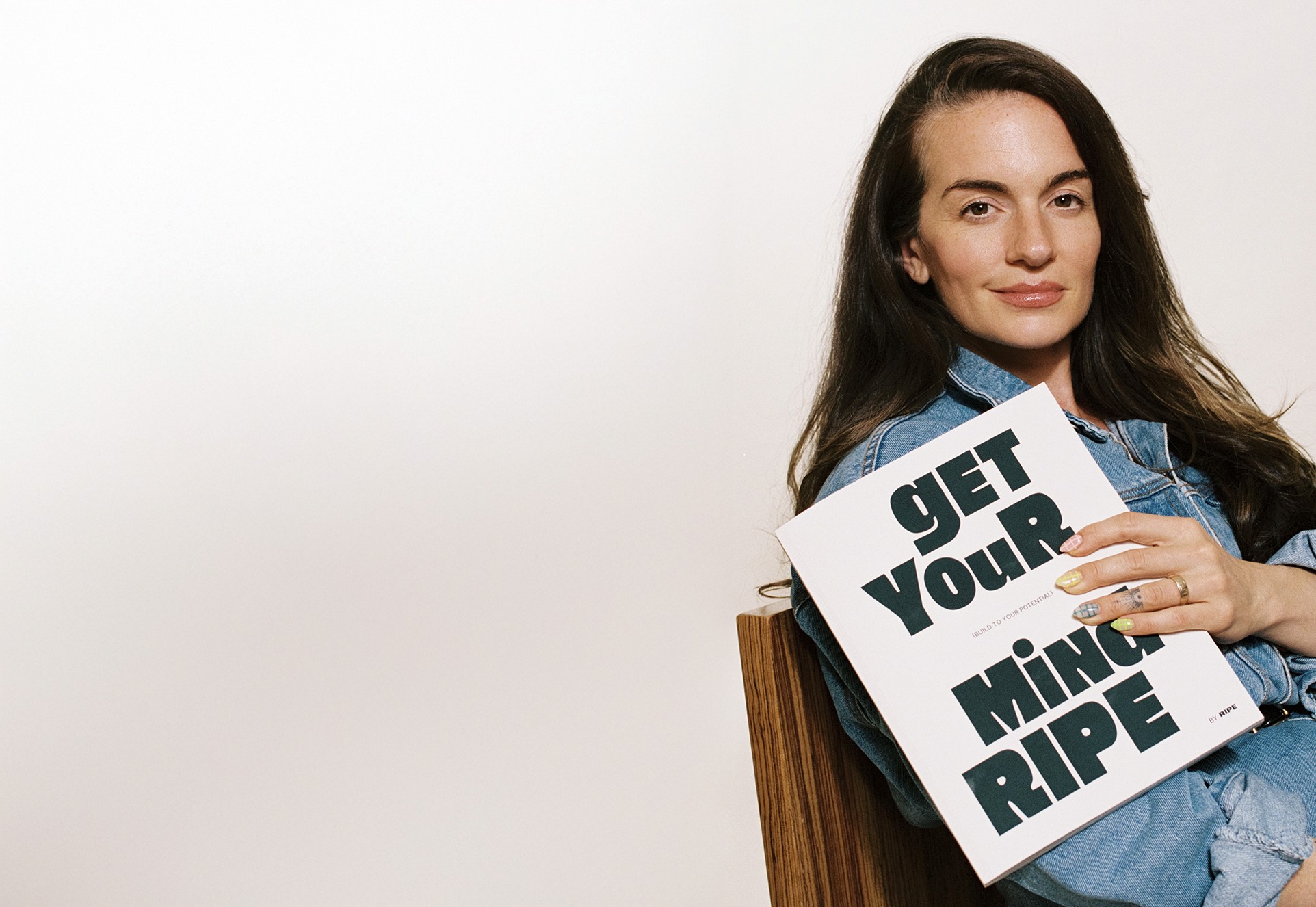Megan Dolce sitting in studio holding GYMR workbook