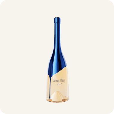 Packshot of Chateau Minuty wine bottle with blue design against beige backdrop