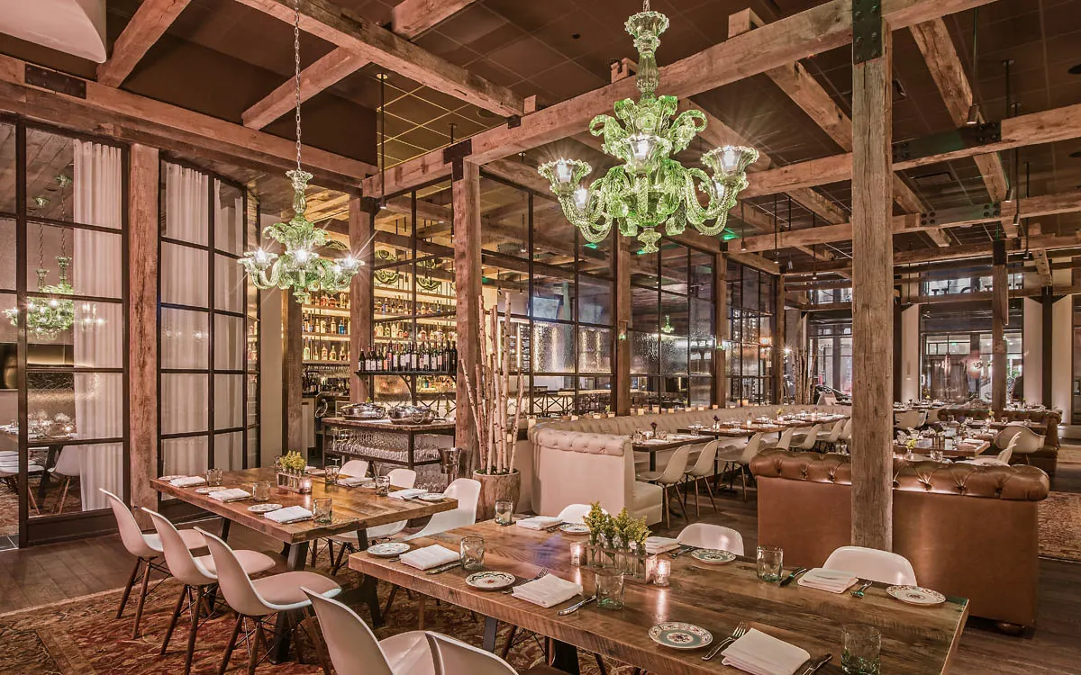 Dining room with wood beams and green glass chandeliers at The Guild House