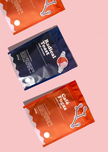 two packets of dog treats on a pink background