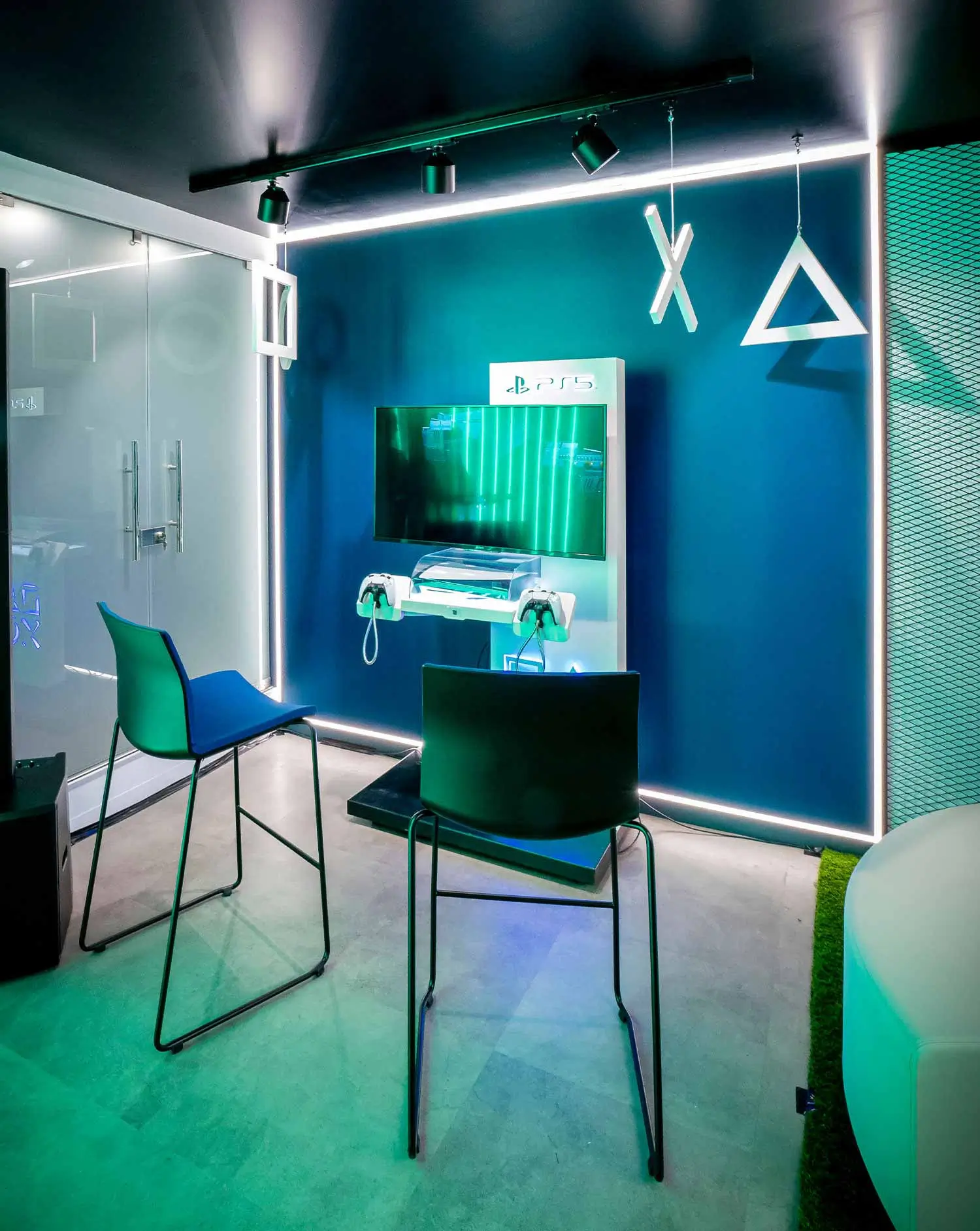 Sala de juegos moderna con consola PS5 y dos sillas.